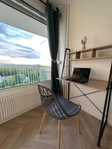 Habitación con escritorio y silla con ordenador portátil. en Appartement vue panoramique Antony, 8mn RER B et C, en Antony