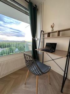 a room with a desk and a chair with a laptop at Appartement vue panoramique Antony, 8mn RER B et C in Antony