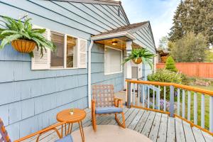 une maison bleue avec une table et une chaise sur une terrasse couverte dans l'établissement Vibrant Tacoma Retreat, Near Point Defiance Park!, à Tacoma