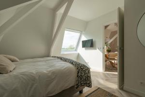 a white bedroom with a bed and a window at New Apartment In City Center By Jose's 6 in Roosendaal