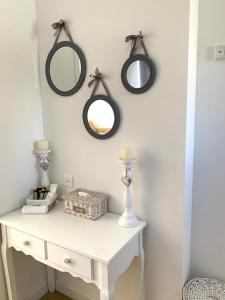een kamer met een witte tafel met spiegels aan de muur bij Chambre d'hôtes de charme MERBLEUESOLEIL in Six-Fours-les-Plages