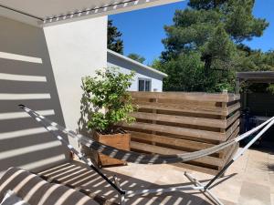 a hammock in front of a house with a fence at Chambre d'hôtes de charme MERBLEUESOLEIL in Six-Fours-les-Plages