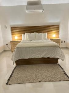 a bedroom with a large bed and two night stands at Villa Sunrise RD in Las Galeras