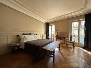 sypialnia z łóżkiem, stołem i oknami w obiekcie Maison Saint-Germain-des-Prés w Paryżu