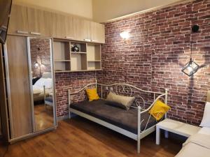 a room with a brick wall and a bench and a couch at Apartment tbilisi central in Tbilisi City