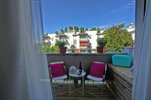 un balcón con 2 sillas y una mesa con una botella de vino en Alba Apartment, en Spinea