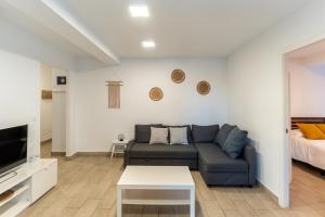 een woonkamer met een bank en een bed bij Apartamento Torre Cervantes, moderno, luminoso, a 5 min de la Playa in Almería