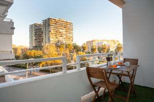 een balkon met een tafel en stoelen bij Apartamento Torre Cervantes, moderno, luminoso, a 5 min de la Playa in Almería