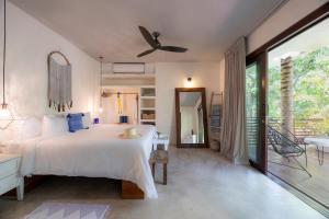 um quarto com uma cama grande e uma varanda em Lula Seaside Boutique Hotel em Tulum