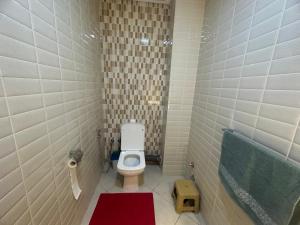 La petite salle de bains est pourvue de toilettes et d'une baignoire. dans l'établissement APPARTEMENT FAMILIAL ELHOUDA, à Agadir