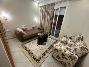 - un salon avec un canapé et une table dans l'établissement APPARTEMENT FAMILIAL ELHOUDA, à Agadir