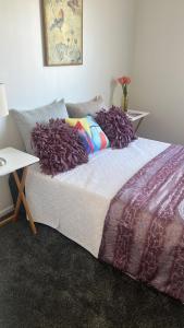 a bed with pillows on it in a room at Auckland airport holiday home in the greens in Auckland