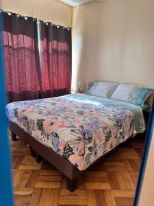 a bedroom with a bed with a quilt on it at hostal NAUU in Concepción