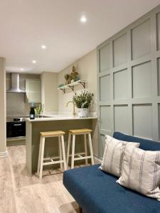ヨークにあるVictoria Bar Walls by Chateau Anna, Central York - free parkingの青いソファとキッチンのあるリビングルーム