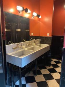 a bathroom with two sinks and a large mirror at The Nolita Express 1927 Hostel in New York