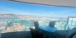 z balkonu ze stołem i krzesłami roztacza się widok na miasto. w obiekcie Luxury Apartment with Swimming pools, Spa and stunning views w mieście Gibraltar
