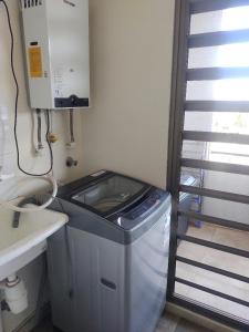 eine kleine Küche mit einem Mülleimer und einem Waschbecken in der Unterkunft Departamento en La Cruz Entre La Calera y Quillota in La Cruz