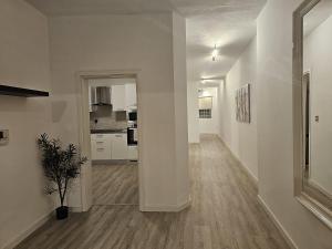 a hallway of a white apartment with a plant at Sea View over Valletta Harbour 3 bedrooms 2 S4 in Sliema
