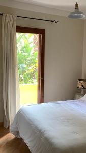 ein Schlafzimmer mit einem weißen Bett und einem Fenster in der Unterkunft NEST HOUSE - ESCLUSIVO APPARTAMENTO Marina di Olbia- MATER OLBIA - Beaches - close to the Airport - PRIVATE PARKING- Full comforts - in Olbia + 36 Fotos