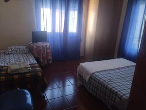 a bedroom with two beds and a table with a chair at Alojamento Local, Cantinho Verde in Corroios