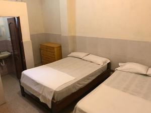 - 2 lits dans une chambre avec un miroir et un lavabo dans l'établissement Hotel Luque, à Guayaquil