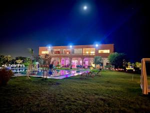 un edificio con piscina por la noche en Domaine Bahi en Marrakech