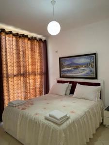 a bedroom with a bed with two books on it at Alvi Apartment 1 in Sarandë +1 photo