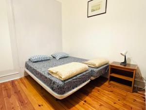 a bedroom with a bed and a lamp on a wooden floor at Fortune Guest house in Lisbon