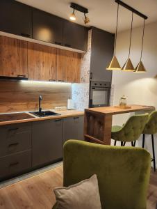 une cuisine avec un évier et une table avec une chaise verte dans l'établissement Apartman MK, à Lukavica