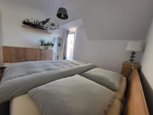 a bedroom with a large bed with pillows on it at Jana Vienna Airport Apartment in Schwechat