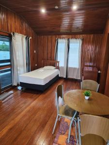 um quarto com uma cama, uma mesa e cadeiras em Sunset View-Villa em Pacific Harbour