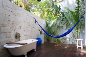 een badkamer met een ligbad op een houten vloer bij Lula Seaside Boutique Hotel in Tulum