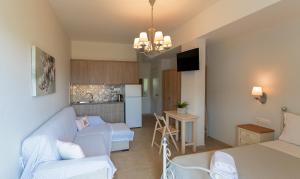 a living room with a couch and a kitchen at Kaiti 's Studios & Apartments in Palaiochóra