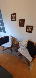 uma sala de estar com duas cadeiras e retratos na parede em Casa de Campo Establecimiento La Leticia em Rafaela