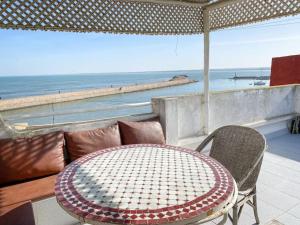 una mesa y sillas con vistas al océano en Duplex Statia vue sur Port, en El Jadida