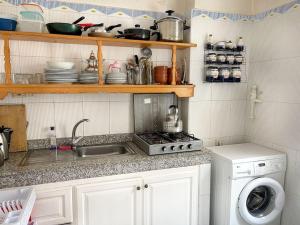 a kitchen with a sink and a stove top oven at Duplex Statia vue sur Port in El Jadida