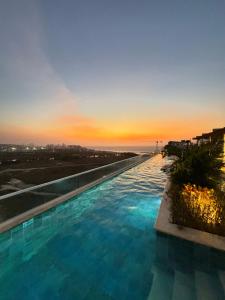 uma grande piscina com um pôr-do-sol ao fundo em Dominique By Stay Q em Cartagena das Índias