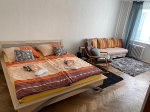 um quarto com uma cama com uma cadeira e um sofá em Apartmán BERLIN em Chodov