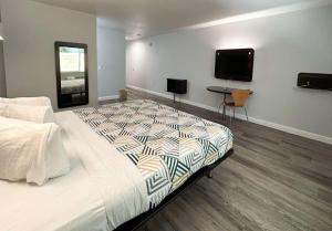 1 dormitorio con 1 cama y TV en la pared en Motel 6-Anaheim, CA, en Anaheim