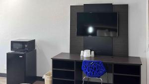 a desk with a television and a blue chair at Motel 6-Lebec, CA in Lebec