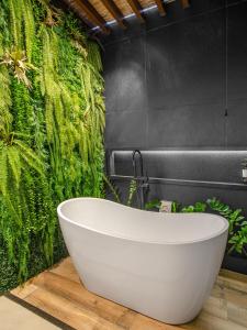 a bath tub in a bathroom with a green wall at PIPA INN Pousada in Pipa