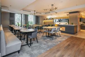 a restaurant with tables and chairs and a kitchen at Radisson Hotel Kaunas in Kaunas