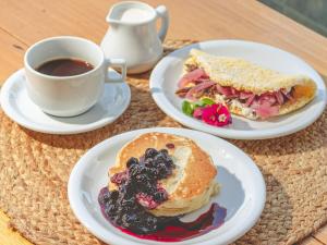 una mesa con dos platos de comida y una taza de café en PIPA INN Pousada en Pipa