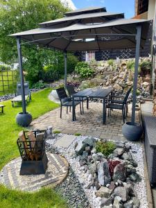 a patio with a table and chairs under an umbrella at Ferienwohnung Oxana im Naturpark Fichtelgebirge in Schönwald