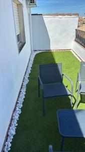 a patio with chairs and grass on a building at ENTOELCENTRO in Baeza