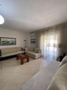 a living room with a couch and a table at Alvi Apartment 1 in Sarandë
