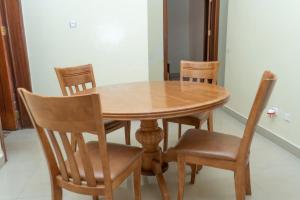einen hölzernen Esstisch mit 4 Stühlen und einem Tisch in der Unterkunft Green Apart Hotel in Kigali
