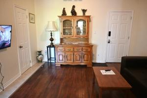 una sala de estar con un armario de madera y una mesa. en Centennial Suite, en Niagara Falls