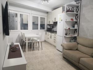 a kitchen and living room with a couch and a table at O RECUNCHO DE MORA in Ribeira