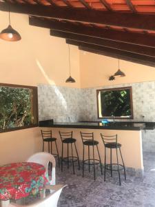a kitchen with bar stools and a counter top at Chalé Veredas e Buritis in Pirenópolis